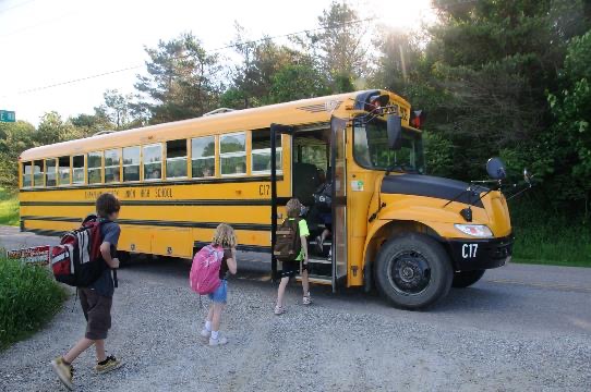 Kids getting on a school bus